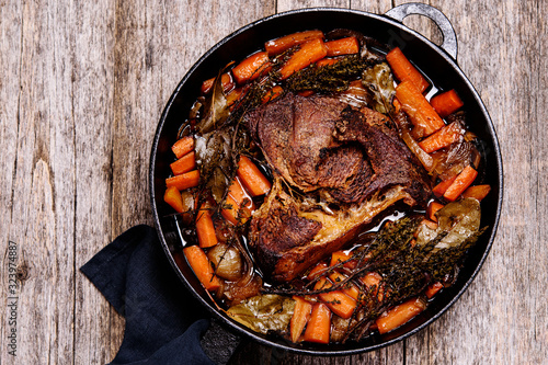 Braised beef brisket big piece with carrots and onion sauce serve in a hot pan