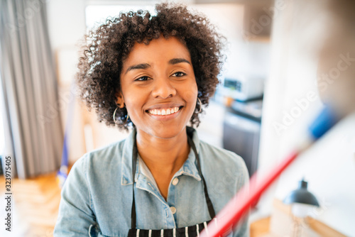Wall Mural Afro woman dusting her new house.