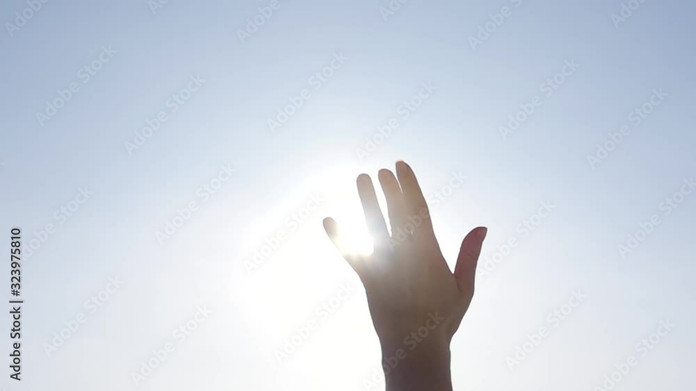 Girl looks at the sun through her hand Girl looks at the sun through her hand