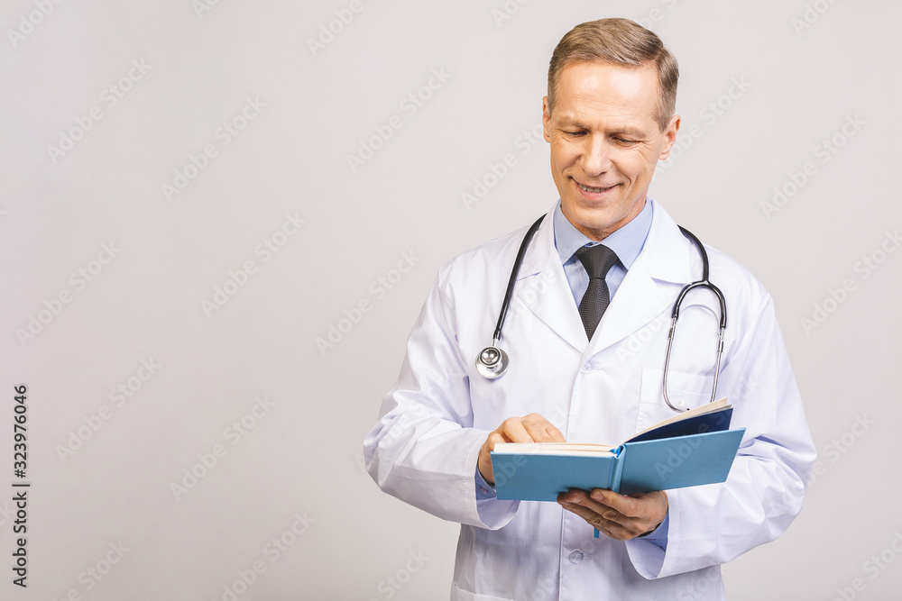 Senior doctor reading a book isolated over grey background. Senior doctor reading a book isolated over grey background.