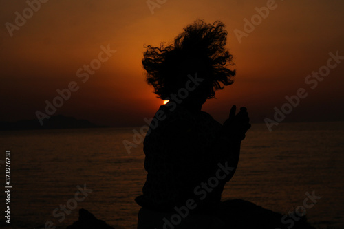 A girl jumping in front of the sunrise