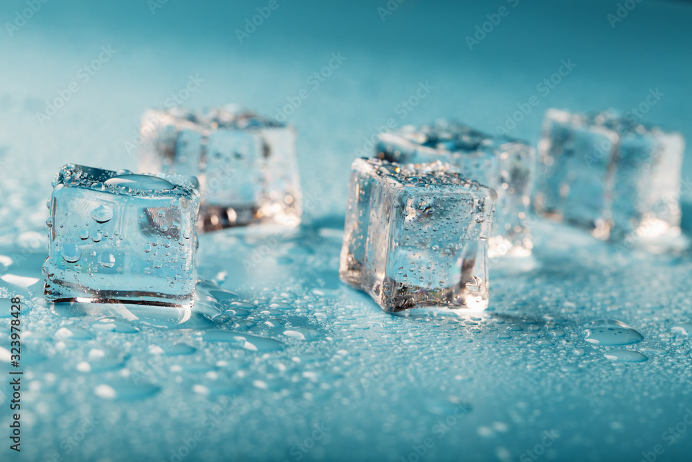 Ice cubes are scattered with water drops scattered on a blue background. Ice cubes are scattered with water drops scattered on a blue background.