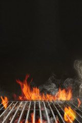Hot empty portable summer barbecue BBQ grill with bright flaming fire and ember charcoal on black background. Cookout concept. Close up, copy space