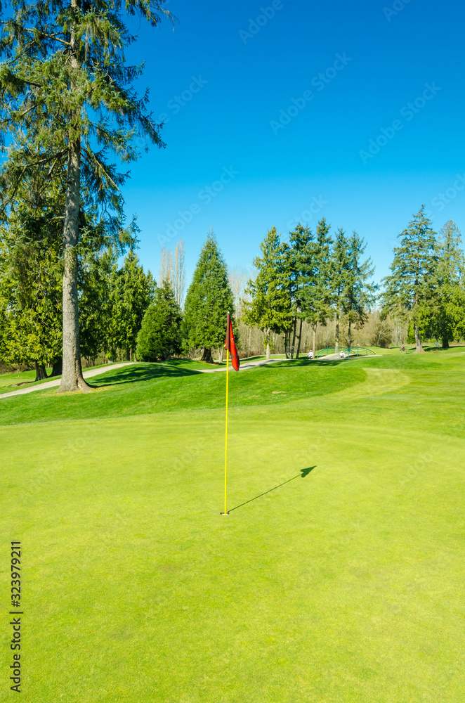 Obraz premium Golf course with gorgeous green and pond.