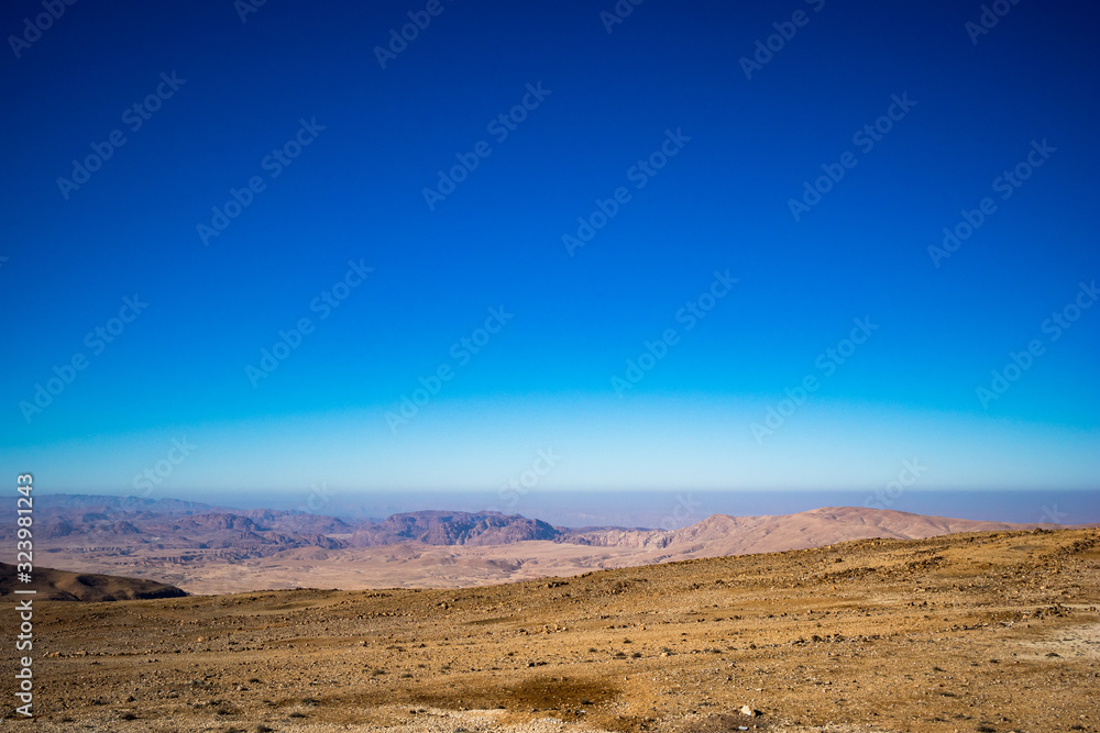 Jordan in winter, desert Uadi Rum or Wadi Rum or Valley of Moon, scenery cloudless blue sky landscape view at the end of January. Travelling in the beautiful Middle East kingdom. Sand and rocks