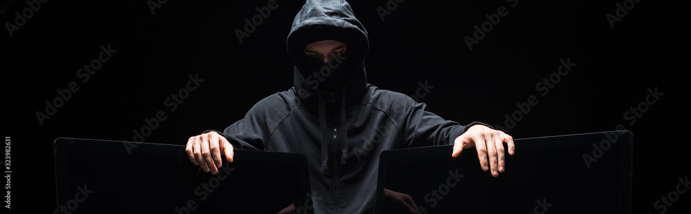 panoramic shot of hacker touching computer monitors isolated on black panoramic shot of hacker touching computer monitors isolated on black