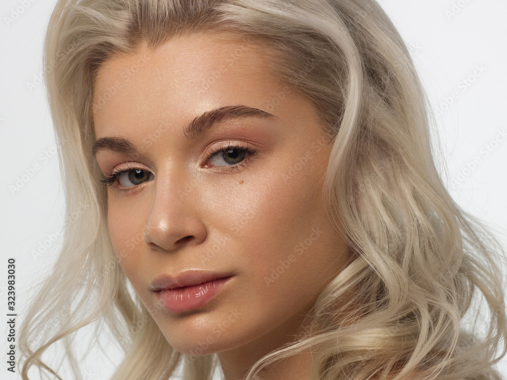 Closeup portrait of a woman with developing straight hair. Sweet tender young girl blonde. Natural lipstick, transparent clean skin. Skin care natural cosmetics in the spa salon or cosmetology. Closeup portrait of a woman with developing straight hair. Sweet tender young girl blonde. Natural lipstick, transparent clean skin. Skin care natural cosmetics in the spa salon or cosmetology.