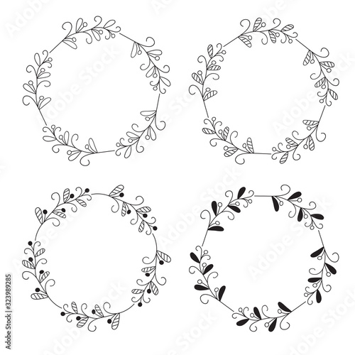 Wreaths of leaves and twigs. Set of four black and white vector round floral frames isolated on a white background.