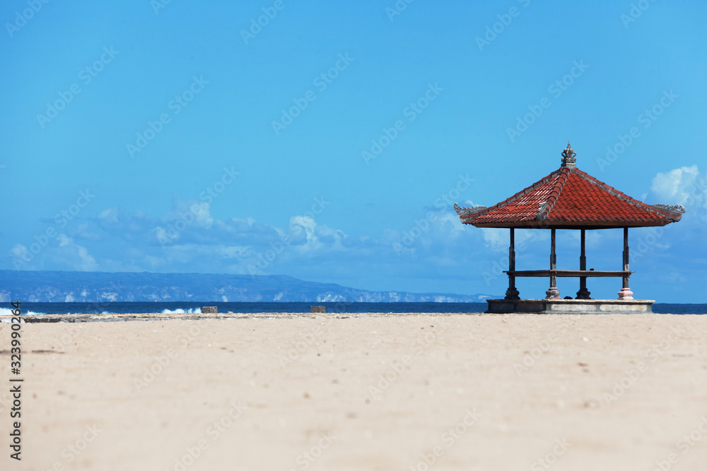 seascape background with bright sun and traditional tent on Bali island, Indonesia