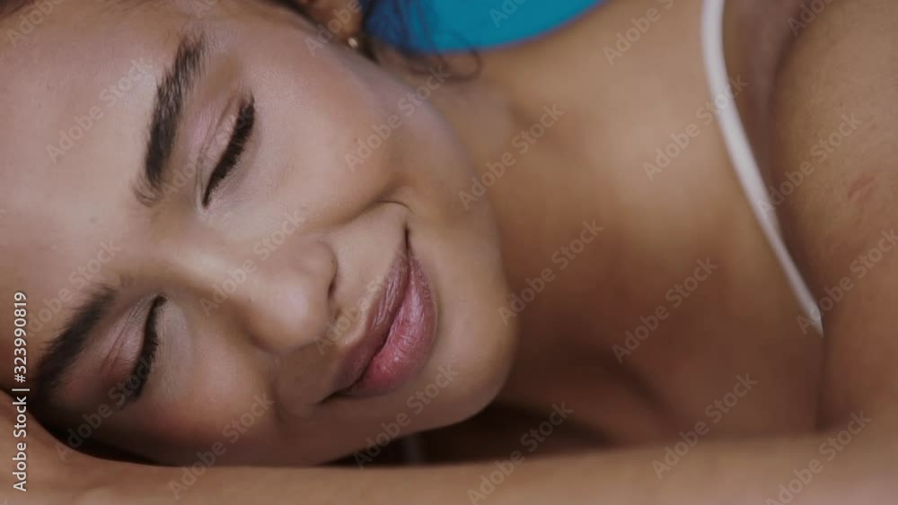 close-up of fresh woman face with dark eyes and eyebrows natural make-up lying on her arm smiling to camera close-up of fresh woman face with dark eyes and eyebrows natural make-up lying on her arm smiling to camera