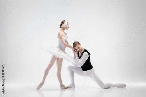 Heart listen. Graceful classic ballet dancers dancing isolated on white studio background. Couple in tender clothes like a white swan characters. The grace, artist, movement, action and motion concept