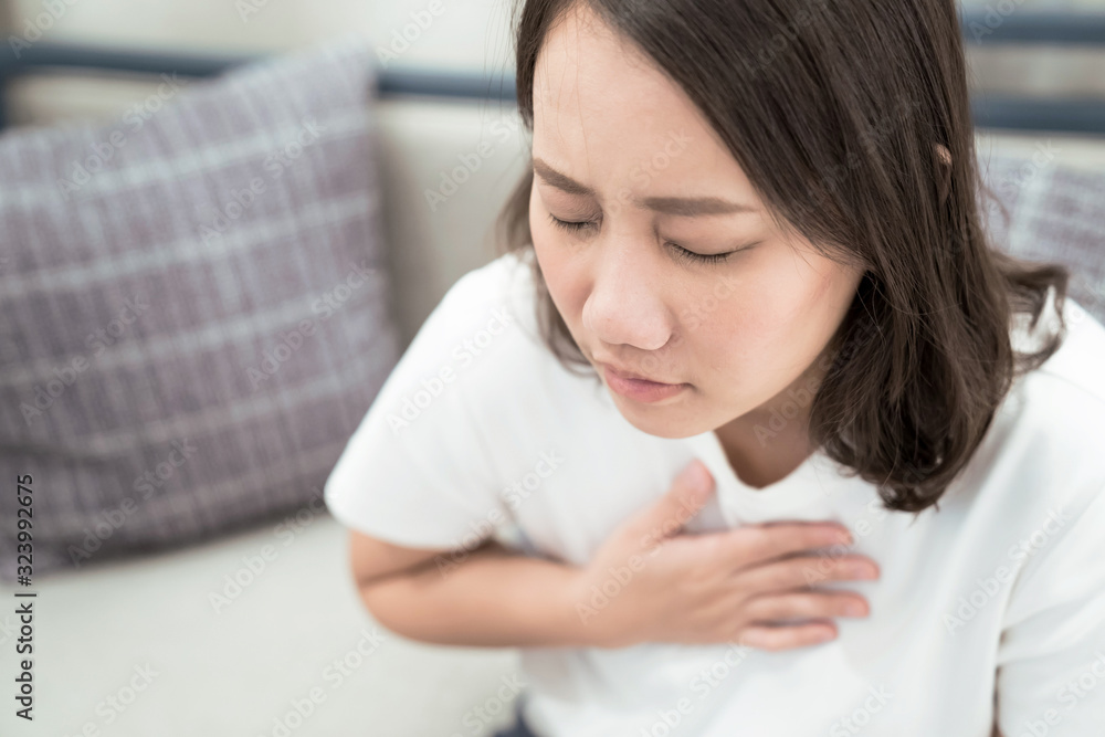 Concepts of health and illness, Asian woman puts her hand on her chest, She felt pain in her chest and had difficulty breathing. Concepts of health and illness, Asian woman puts her hand on her chest, She felt pain in her chest and had difficulty breathing.