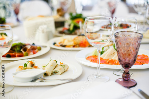 Served for banquet restaurant table with dishes, snack, cutlery, wine and water glasses, european food, selective focus