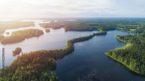 Scenic view of beautiful sunrise or dawn above the lake at spring or early summer evening with blue sky. Finland.