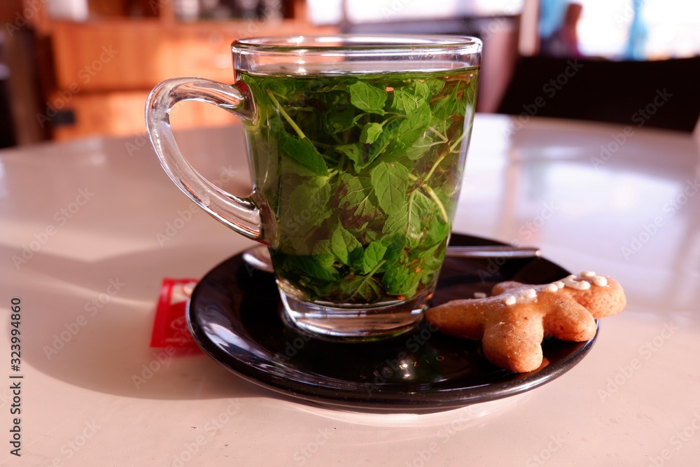Transparent сup of Moroccan mint tea and ginger cookie on the side Transparent сup of Moroccan mint tea and ginger cookie on the side