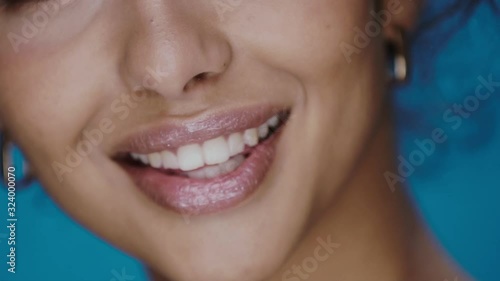 close-up of woman turning to camera and laughing with wide perfect smile and clean white teeth