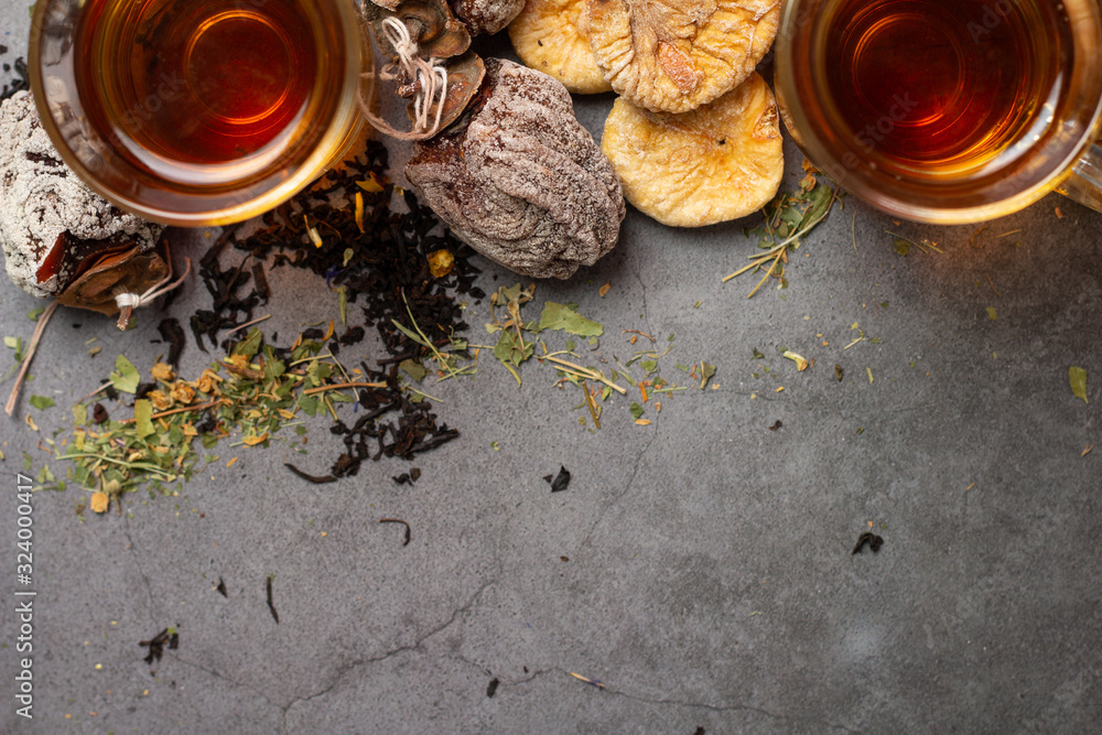 cups of tea and dried fruits and place for text on a gray background