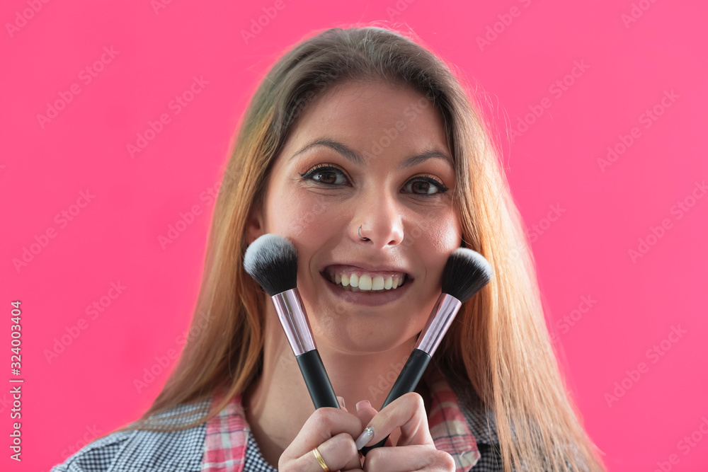Beautiful woman holding makeup brushes and smiling Beautiful woman holding makeup brushes and smiling