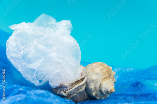 Plastic pollution in ocean concept. Carrier bags in sea shell. Shellfish in bad ecology concept.