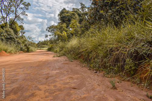 Estrada de terra laranja em bioma de Cerrado
