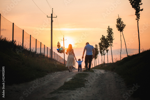 Happy family: mother, father, children son on nature on sunset