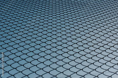 Background of Chainlink fence with blue sky in the background. Backgrounds concept. 