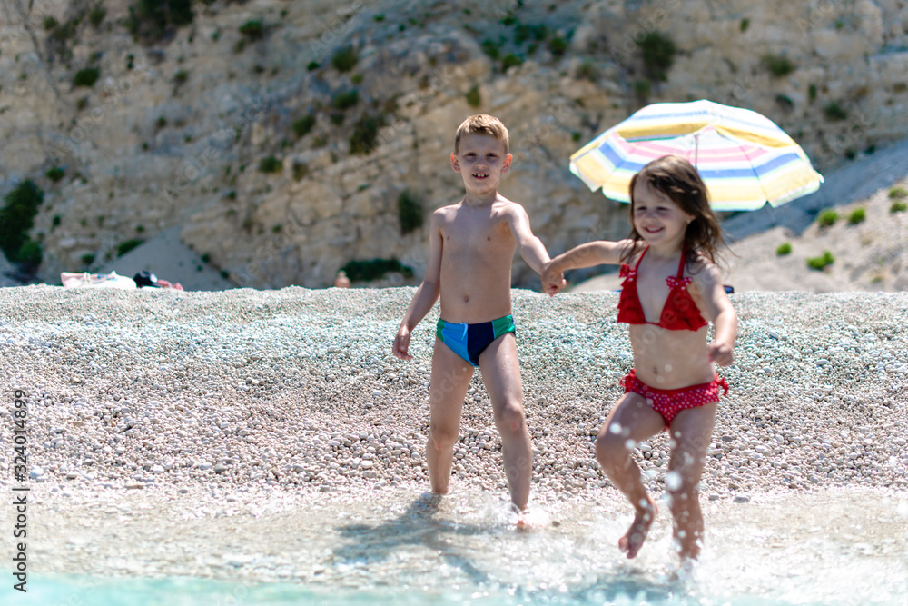 Little girl and boy running in the water Little girl and boy running in the water