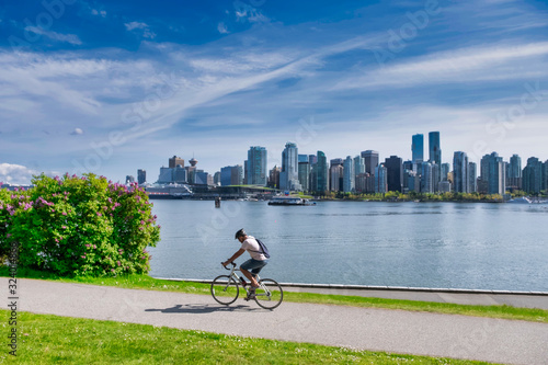 Obraz na płótnie VANCOUVER - MAY 05 2019: Downtown Vancouver, Canada.View of Downtown Vancouver, from Stanley park, man on his bike in foreground w salonie