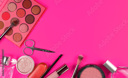 Various decorative makeup cosmetics on pink background. Different beauty essentials for women.