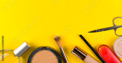 Fototapeta Naklejka Na Ścianę i Meble -  Various decorative makeup cosmetics on yellow background. Different beauty essentials for women.