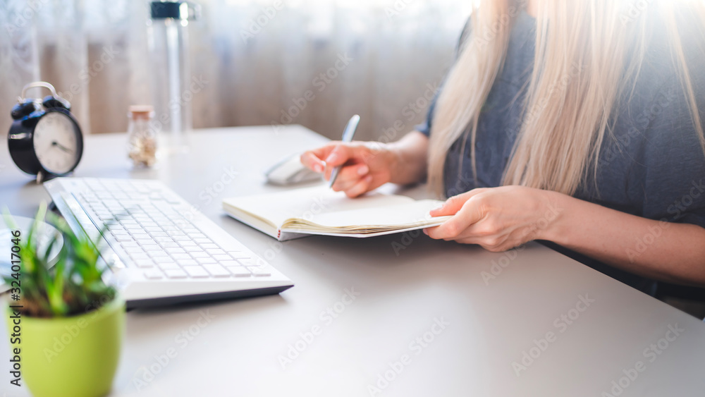 a young girl sits at a desk and makes notes in a notebook a young girl sits at a desk and makes notes in a notebook