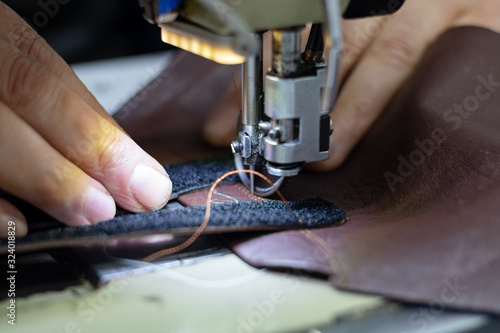Foto Shoemaker sewing a leather and velcro for making a shoe.