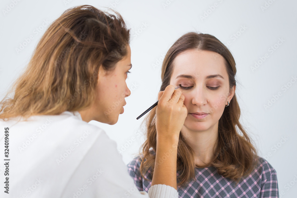 Beauty and cosmetics concept - Make-up artist doing professional make up of young woman Beauty and cosmetics concept - Make-up artist doing professional make up of young woman