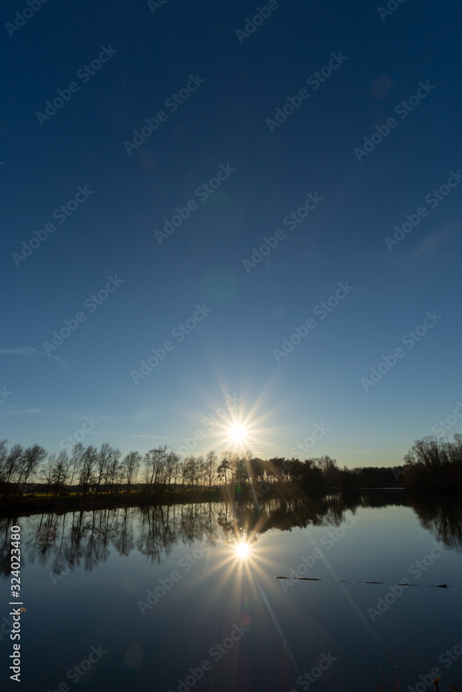 Mirror forest lake with reflection in winter sunny day, de Kempen regio in North Brabant, Netherlands