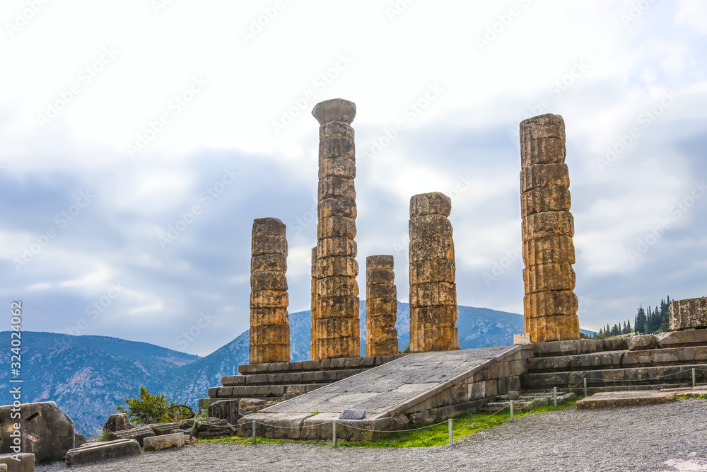 Reconstructed columns of Temple of Apollo at Delphi Greece overlook valley with far-off mountains on foggy day