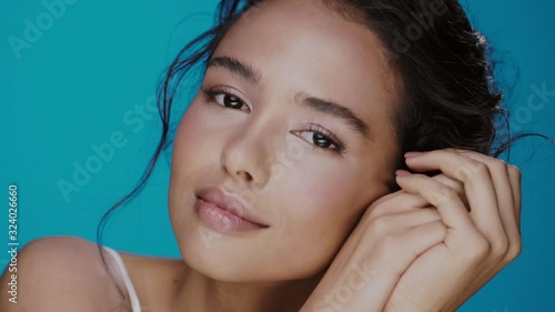 Sensual healthy girl with perfect skin and dark big eyes softly posing and looking to camera