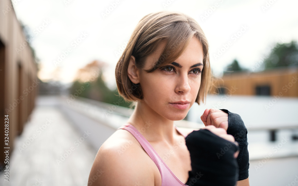A young woman practising karate outdoors on terrace. A young woman practising karate outdoors on terrace.