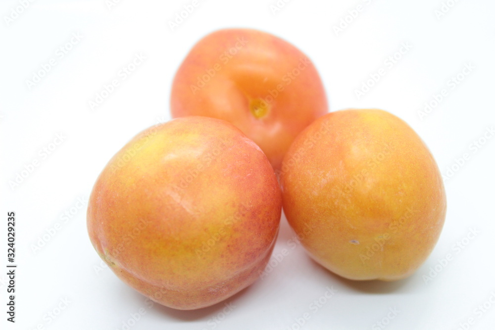 Beautiful delicious orange plums are located on a white background Beautiful delicious orange plums are located on a white background