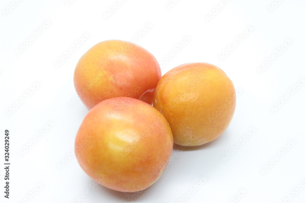 Beautiful delicious orange plums are located on a white background Beautiful delicious orange plums are located on a white background