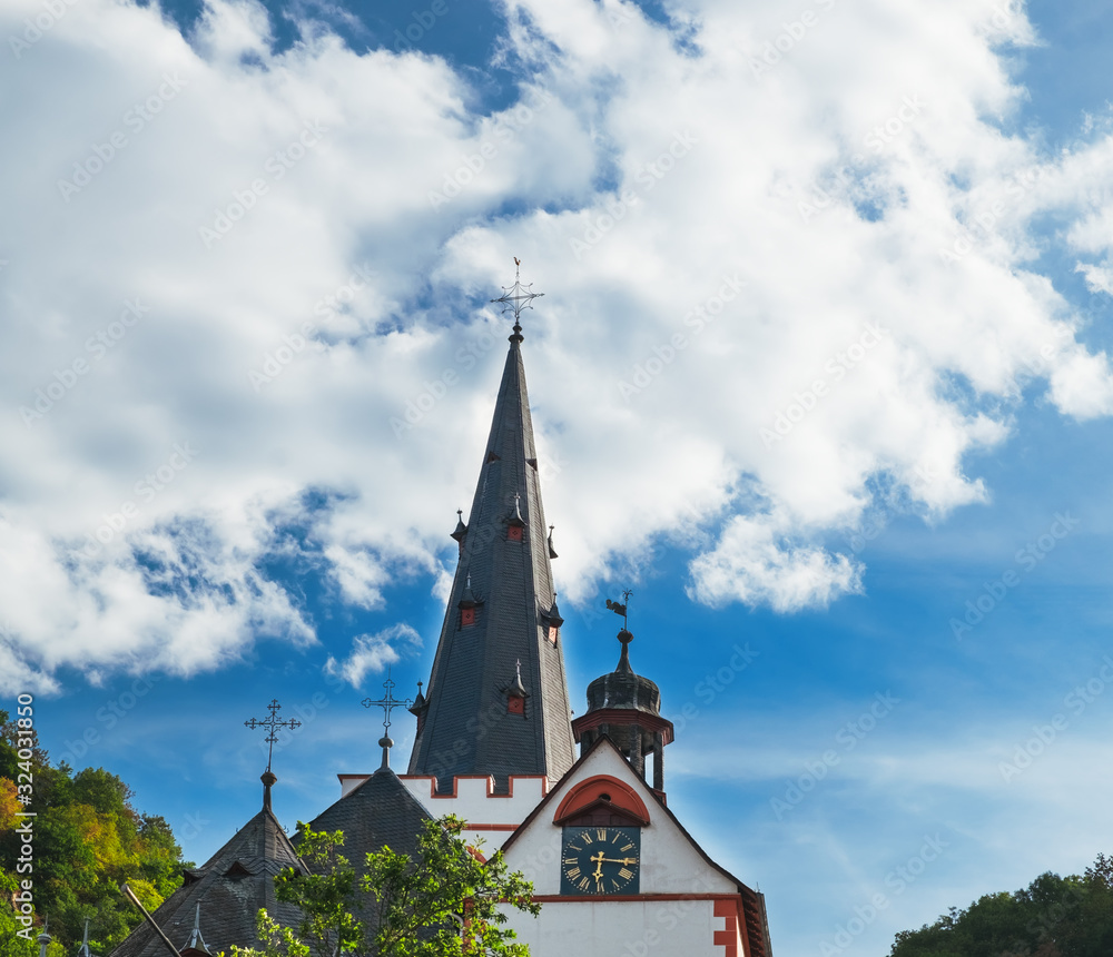 Silhouette of German church bell tower with antique clock, Stiftskirche St Goar Evangelical Church under blue cloudy sky, located in St Goar Town, Germany Silhouette of German church bell tower with antique clock, Stiftskirche St Goar Evangelical Church under blue cloudy sky, located in St Goar Town, Germany