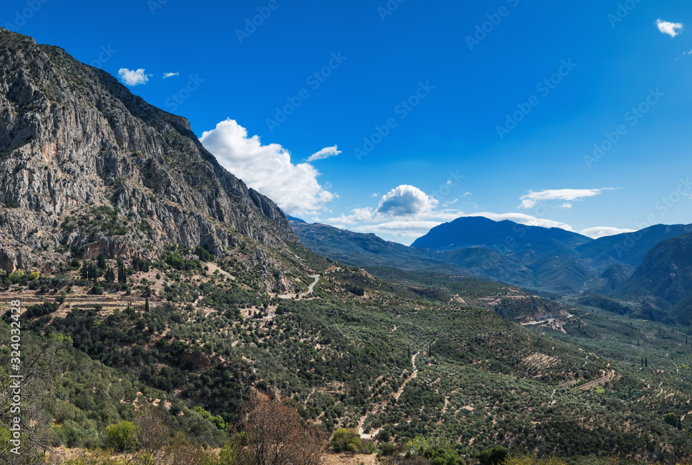 Greek landscape, picturesque mountains and blue sky in Delphi, Greece. Coniferous forest on mountain slope and hillside