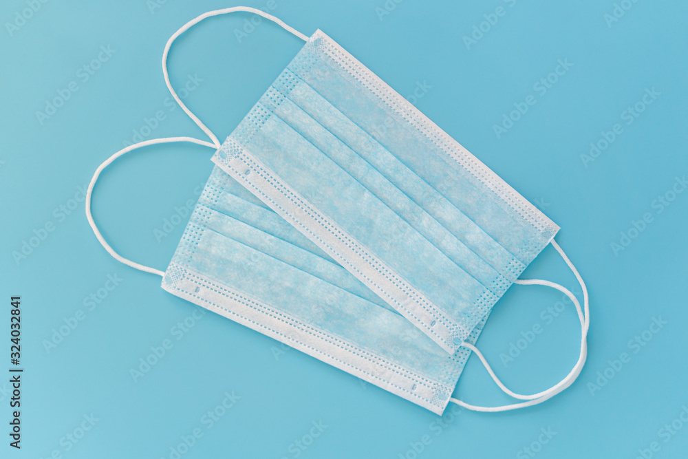 Respirator on a blue background. Protection against viruses and bacteria with a medical mask Respirator on a blue background. Protection against viruses and bacteria with a medical mask