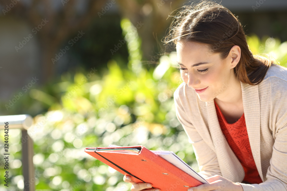 Fotografie Studious student reading notes in a park or campus