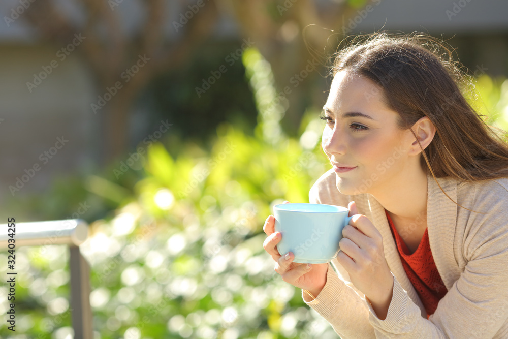 Woman with a coffee cup contemplating at the park Woman with a coffee cup contemplating at the park