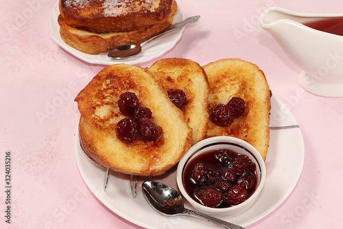 French toasts on a pink table with breadcrumbs. Fried bread with milk and scrambled eggs, concept of a modern bakery. Healthy traditional french breakfast.