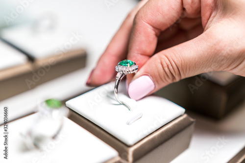Картината върху платно White hand picking up wedding emerald ring in a box