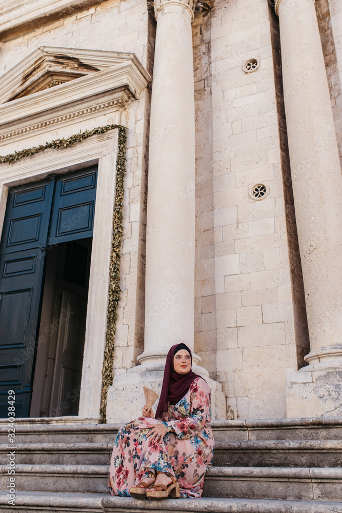 Portrait of beautiful woman with hijab standing in front of old church, historical building, in Dubrovnik, Croatia. Portrait of beautiful woman with hijab standing in front of old church, historical building, in Dubrovnik, Croatia.