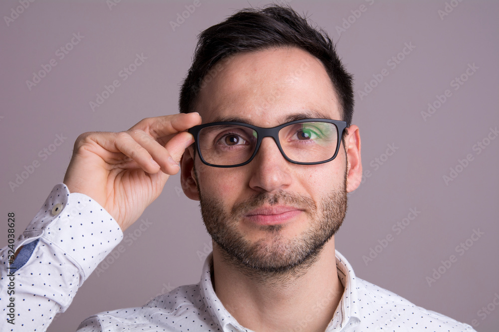 Portrait of a handsome young man with black glasses. Serious pose. Portrait of a handsome young man with black glasses. Serious pose.