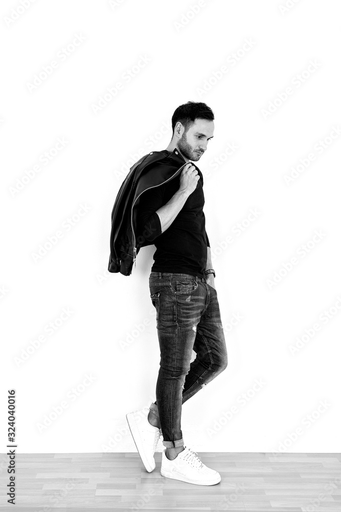 Naklejka premium Handsome model in the studio. Pretty man with jacket. Fashion shooting.