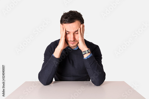 Young businessman meditating on the table. Man with headache